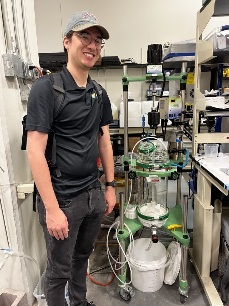 Lucas Crane standing beside a urine diversion system 