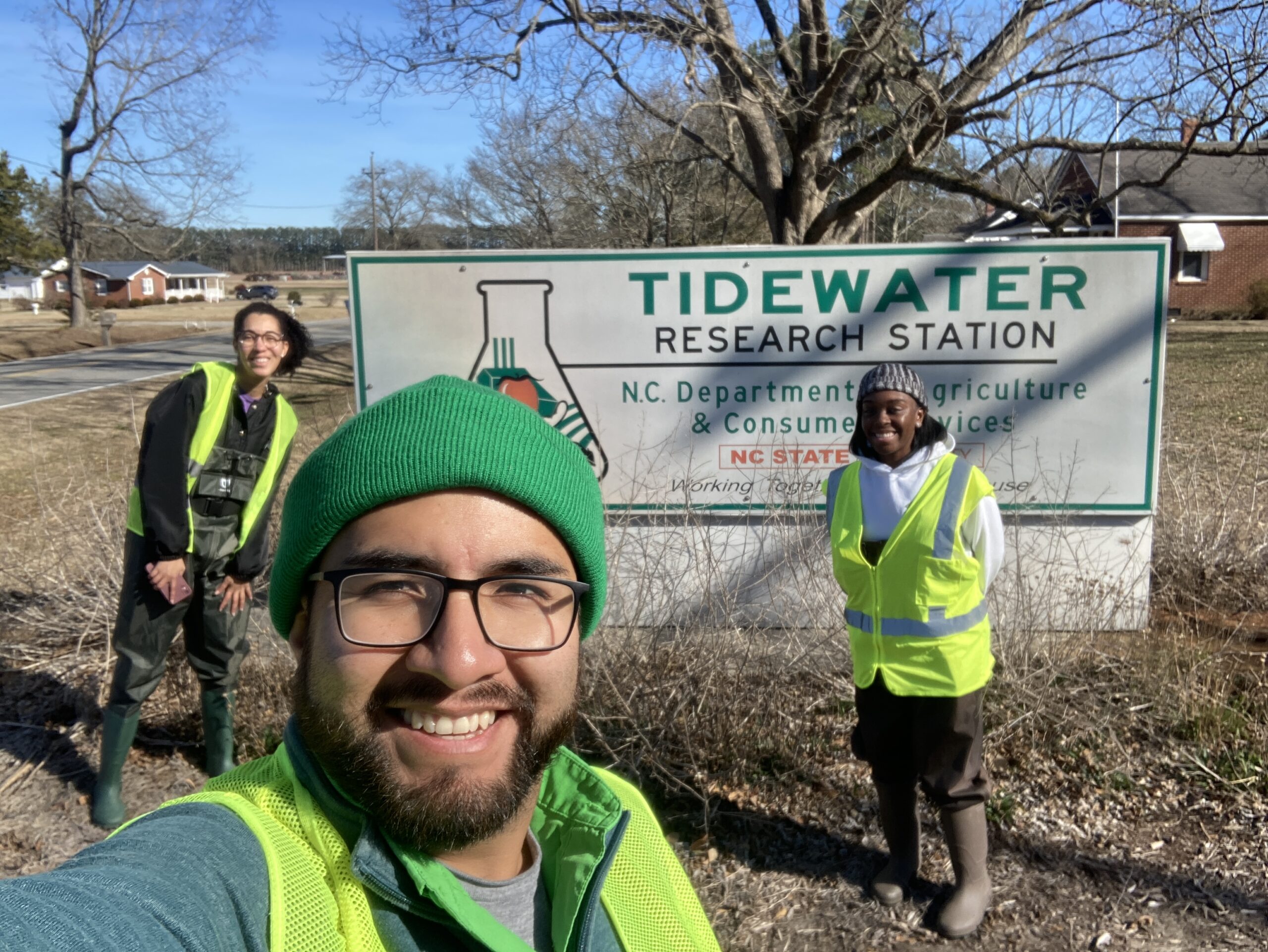Selfie of three STEPS scholars, standing in front of the Tidewater Research Station. 