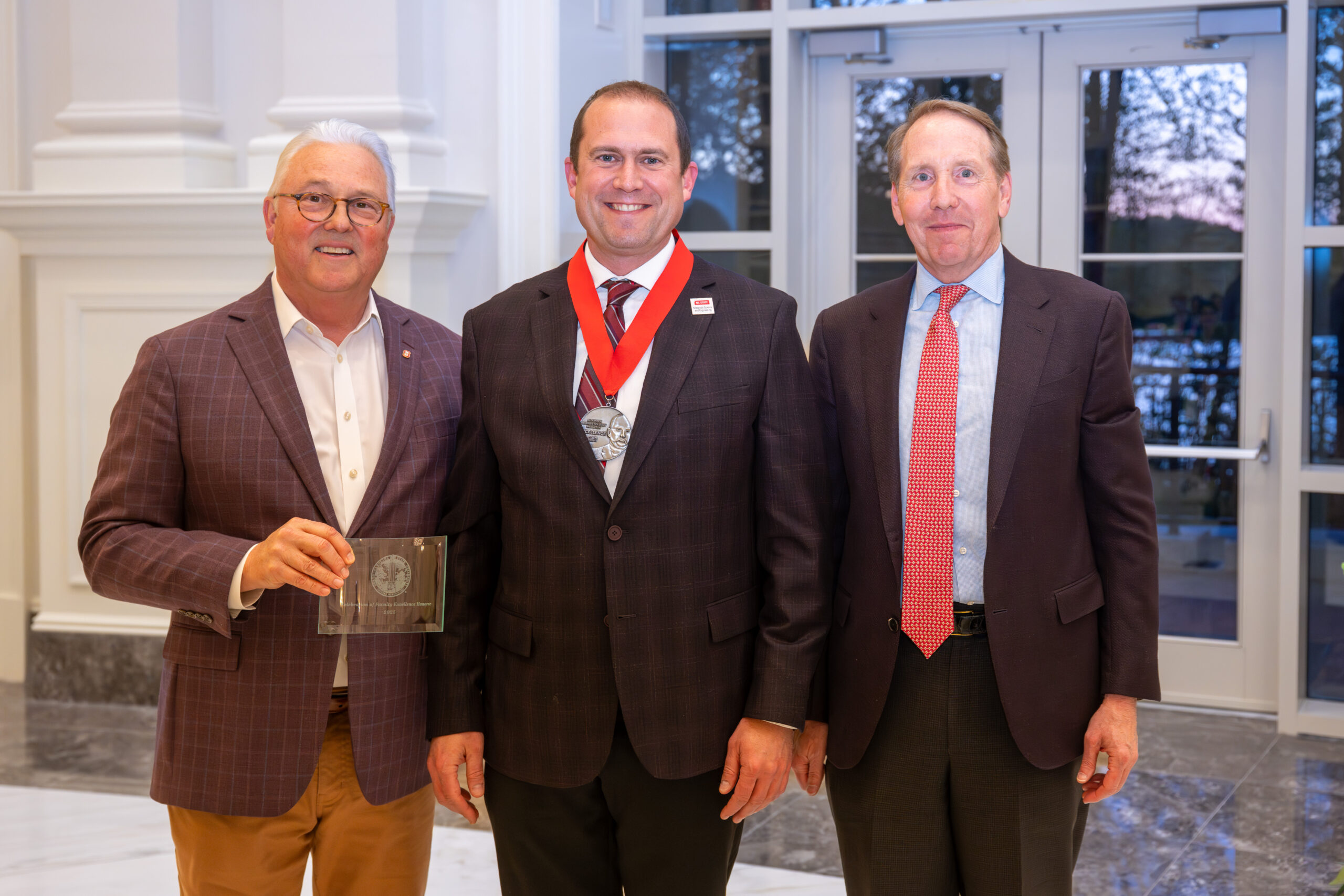 Jacob Jones winning Holladay medal with NC State Chancellor and Board of Trustees chair